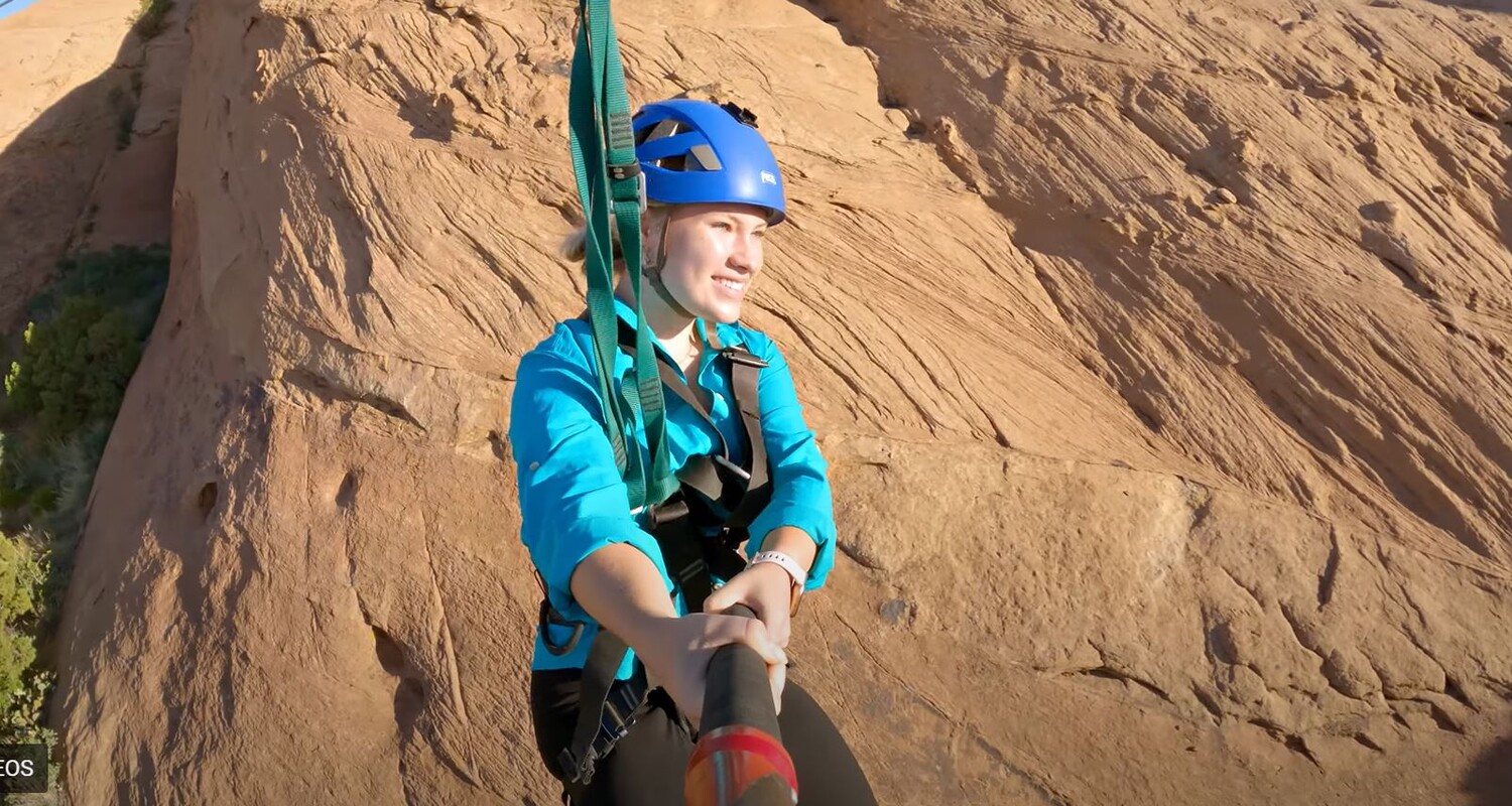 a woman wearing a helmet and harness